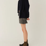 Model wearing The Garment Taylor Mini Plaid Skirt styled with a knit sweater and boots