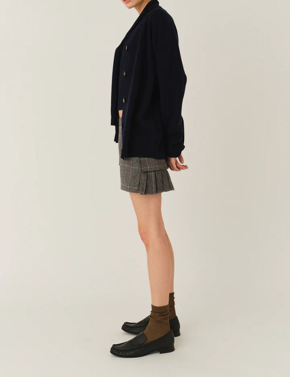 Model wearing The Garment Taylor Mini Plaid Skirt styled with a knit sweater and boots