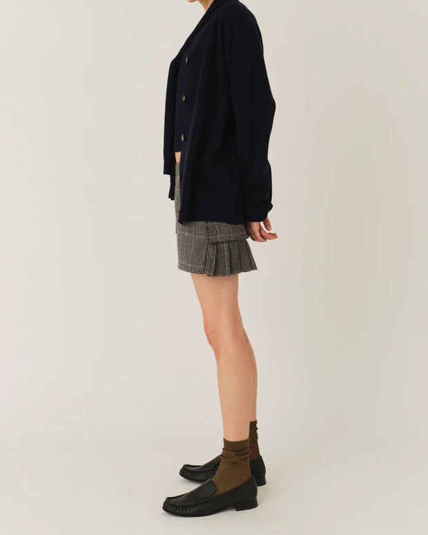 Model wearing The Garment Taylor Mini Plaid Skirt styled with a knit sweater and boots