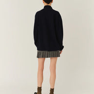 Model wearing The Garment Taylor Mini Plaid Skirt styled with a knit sweater and boots