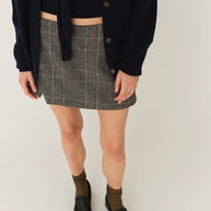 Model wearing The Garment Taylor Mini Plaid Skirt styled with a knit sweater and boots